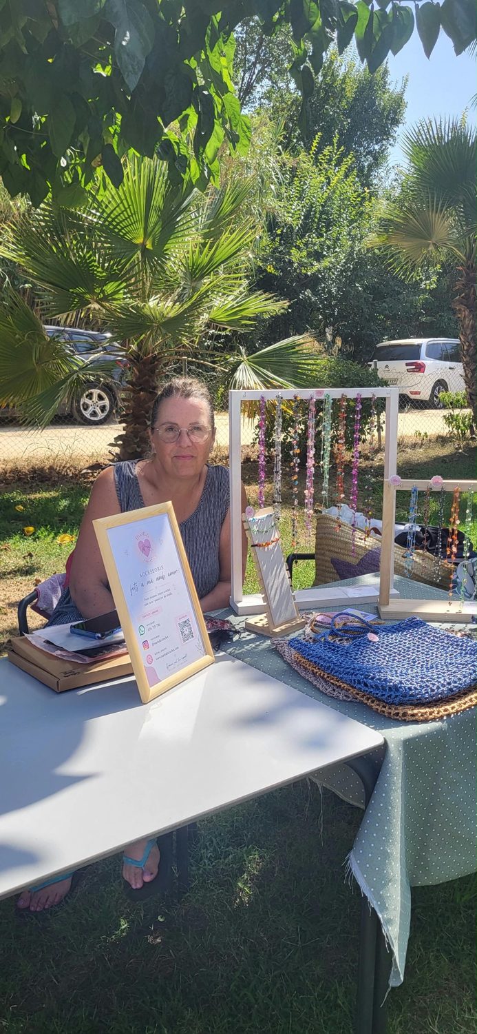 Marta en su stand de Martuki Crochet, con collares colgados y bolsos de rafia